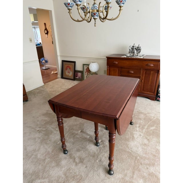 This is a solid cherry wood dining table by Carl Forslund of Grand Rapids MI. It features an oval top with several leaves,...