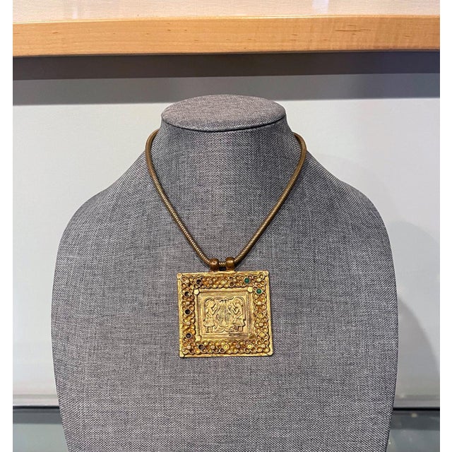 A gilt bronze necklace with chain and a square plaque on the subject of "Adam and Eve in the Garden of Eden" with apple...