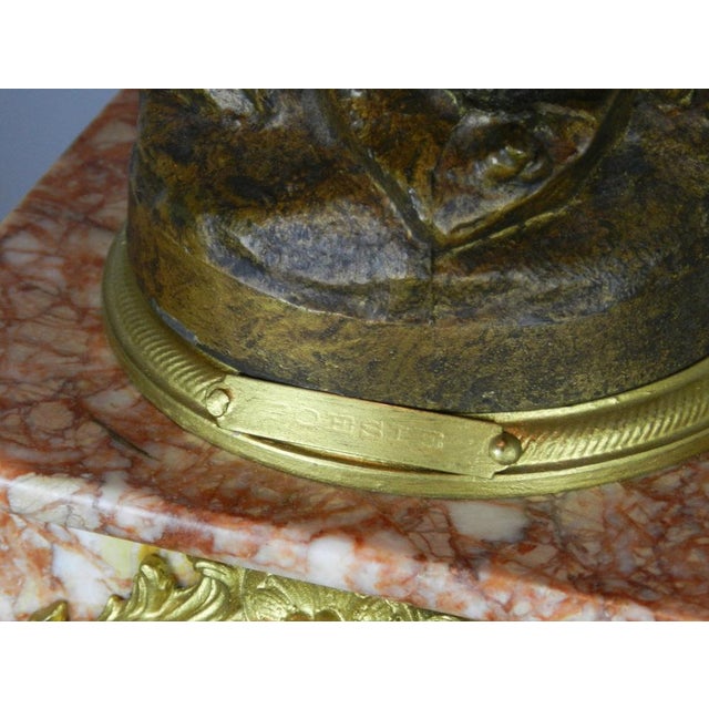 An antique French bronzed spelter clock set with its pair of matching gilt candelabra/garniture. The finely cast figurine...