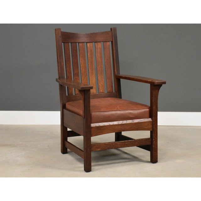 Crafted in the enduring Arts & Crafts tradition, this L. & J.G. Stickley armchair showcases solid quarter-sawn oak, broad...