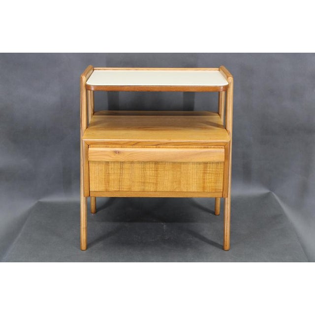 A restored mid-century nightstand produced in 1960s Czechoslovakia, executed in maple wood with maple veneer and topped...