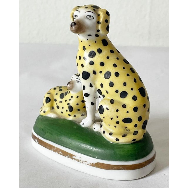 A wonderful pair of black and yellow dalmatians on a painted green base. These are 18th century Chelsea porcelain. They...