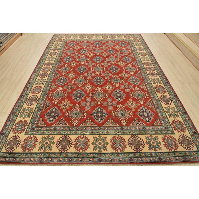 A tribal Caucasian Kazak rug hand-knotted with an all-wool pile on a cotton foundation. This oriental rug features an all-...
