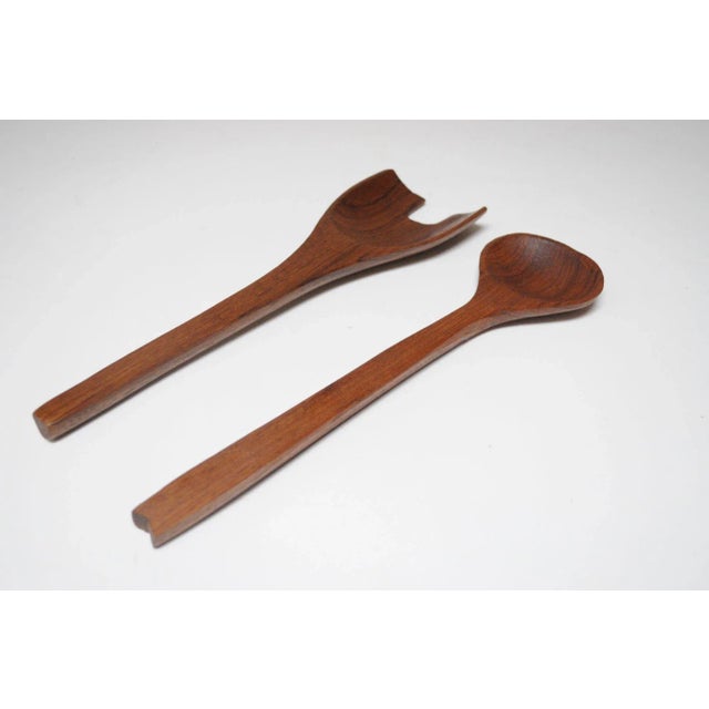 Mid-Century Modern Teakwood Salad Tongs featuring a deeply sculpted fork with exaggerated gap for easier grasp and spoon...