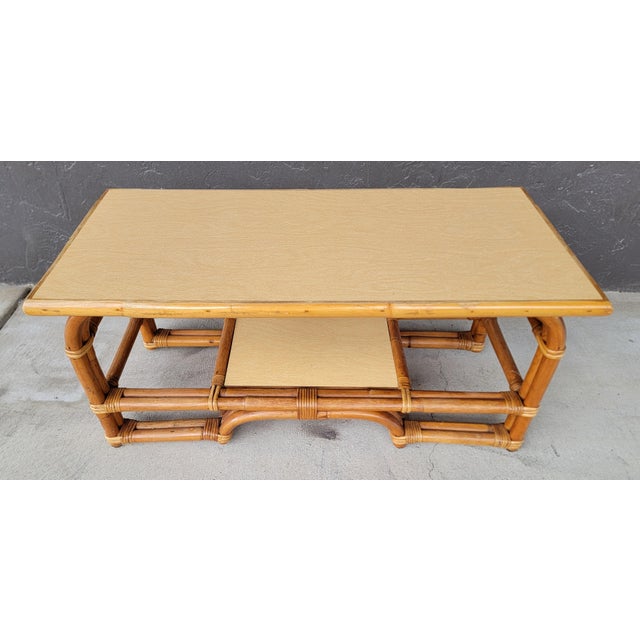 Unusual design to this 1950's bamboo coffee table. Color coordinated Formica top and lower shelf add durability. Magazine...