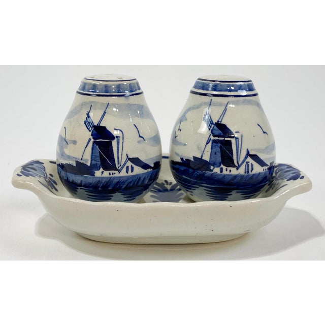 Vintage hand-painted Delft style ceramic salt and pepper shakers with corresponding tray. Intricate and detailed windmill...