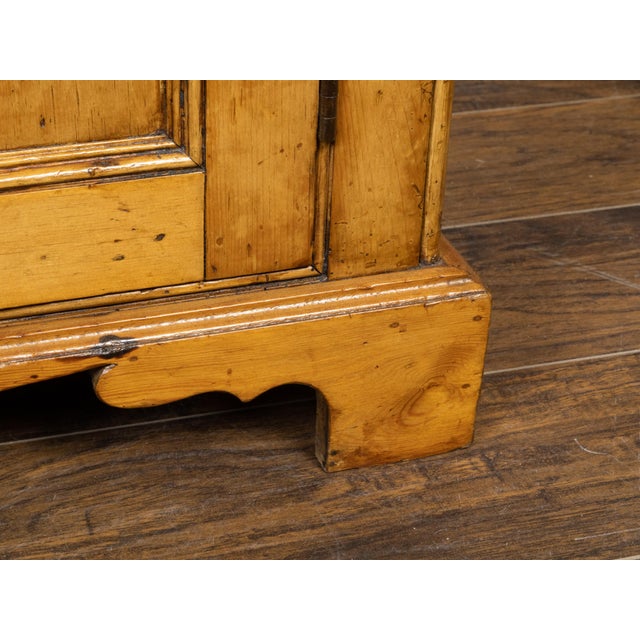 A French pine buffet from the 19th century, with two doors, carved ogee bracket feet, white pulls and nice patina. Created...