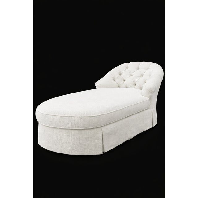 A timeless chaise lounge defined by its softly tufted backrest and elegant, flowing silhouette. Upholstered in a refined...