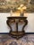 Elegant 20th-century giltwood demilune console table featuring a shaped marble top and beautifully carved decorative...