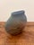 A sculptural vintage studio pottery vase handmade in Brazil. Its flattened organic form features a rough, tactile surface...