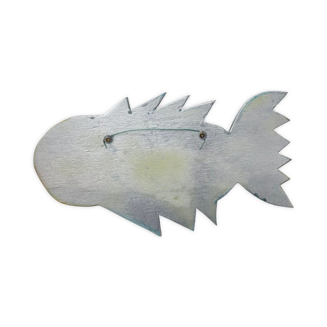 This signed mixed media hanging folk art fish by Pat Custer Denison showcases a playful, expressive interpretation of form...