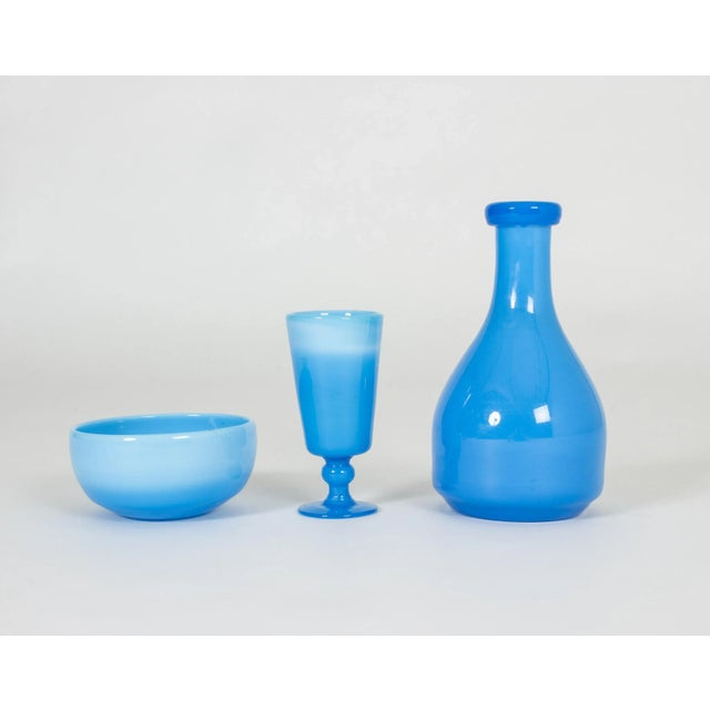 Set of three glass vessels by Erik Höglund; a bowl, a goblet and a flask, made from thick, strikingly sky blue, opaque...