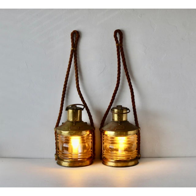 Vintage British masthead lights turned to lamps with rope for hanging. These fabulous brass ship lanterns feature a heavy...