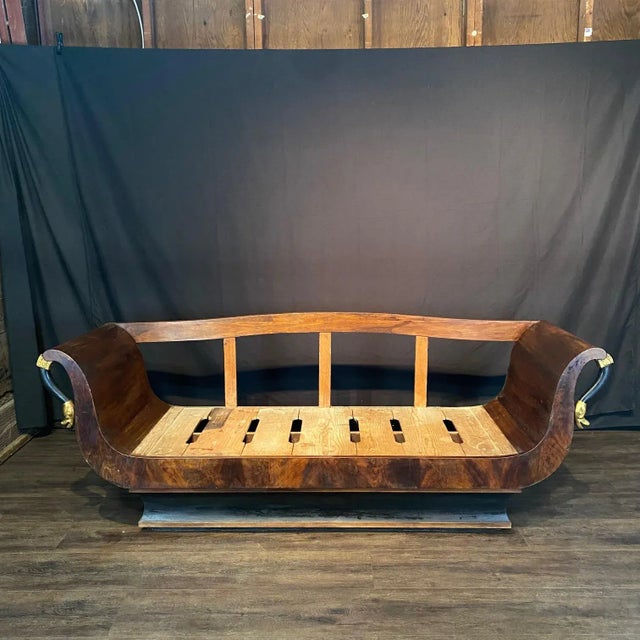 A super elegant romantic French Empire walnut sofa having sexy curves, ebonized base and details with two gilded swans...