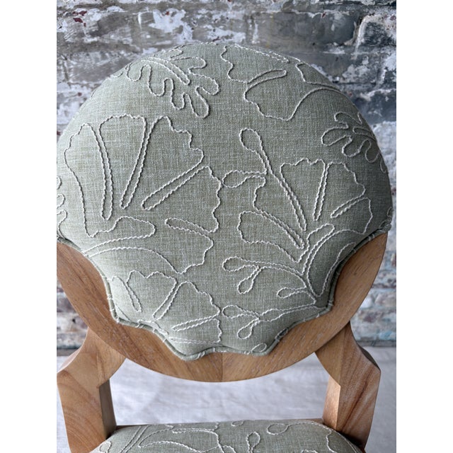 A brand-new vanity or accent chair featuring a sculptural natural wood frame with a softly upholstered seat and rounded...