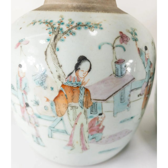We are offering this pair of Famille Rose enameled ginger jars. These two ginger jars have scenes of figures in a garden...