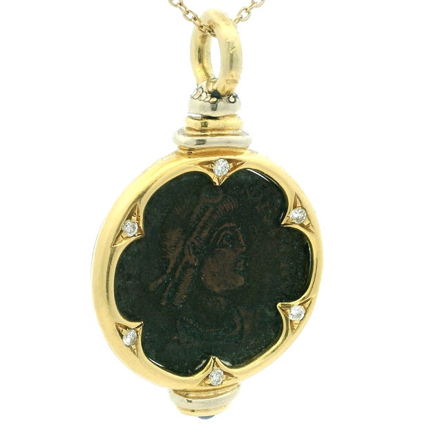 A distinctive vintage pendant crafted in 18K yellow gold, centered by an ancient coin displayed within a sculptural...