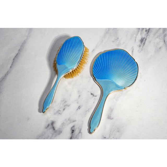 An exquisite example of English Art Deco luxury, this powder blue guilloché enamel sterling silver vanity set is a...