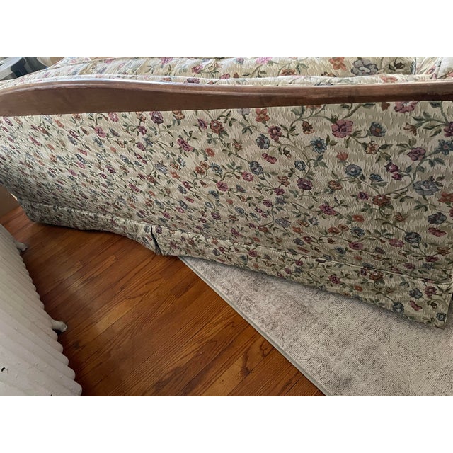 Beautiful vintage traditional three-seat sofa featuring a substantial exposed wood frame, elegant rolled arms, loose seat...