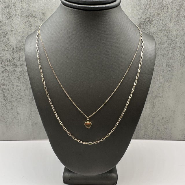 This two layer heart necklace is crafted in 10kt yellow gold and features a stylish layered design with a heart motif. The...