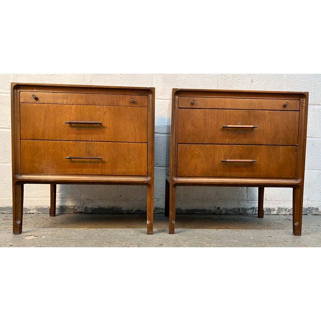 A classic pair of vintage walnut nightstands offering the perfect combination of style, functionality, and timeless mid-...