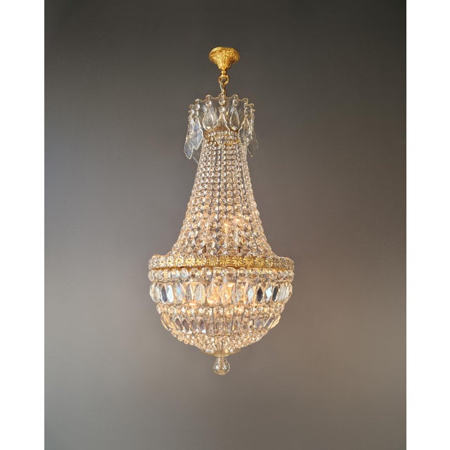 Antique Empire Crystal Chandelier in Brass, France circa 1930 An elegant crystal chandelier in the classic Empire style...