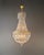 Antique Empire Crystal Chandelier in Brass, France circa 1930 An elegant crystal chandelier in the classic Empire style...