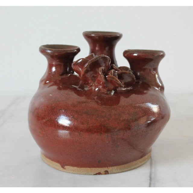 Vintage brown studio art pottery 3- stem bud vase with floral motif. Stamped by artist near base. Minor wear. No chips.