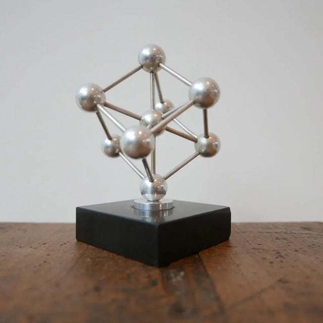 A small desk top model of the atomium building in brussels. marble base, metal model. belgium, c1960s. some small nicks...