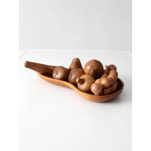 This mid-century Tahitian carved wood fruit bowl set includes a sculptural teardrop-shaped bowl and a collection of hand-...