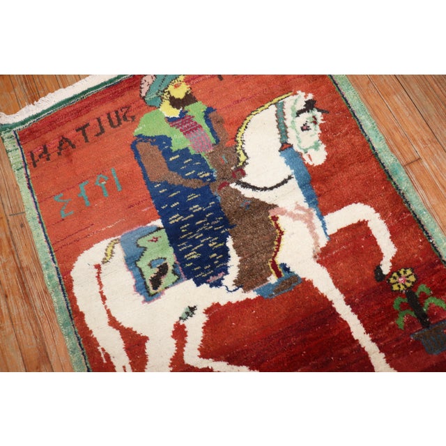 Vintage Turkish Pictorial Rug depicting a bearded gentleman riding on his horse on a red ground. dated 1973, the turkish...