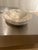 The Curvo Bowl by Michael Verheyden in Travertino Antico is crafted from natural stone, showcasing richly veined patterns...