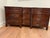 Stately mahogany wood dresser from Milling Road by Baker Furniture. This piece has a dark brown finish with a distressed...