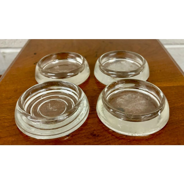 This is a gorgeous set of four vintage, likely antique, glass furniture coasters, caster cups, floor protectors, or carpet...