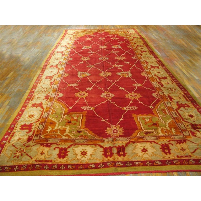 This is a very special Ushak carpet. The strong red field has a wandering lozenge lattice punctuated with various...