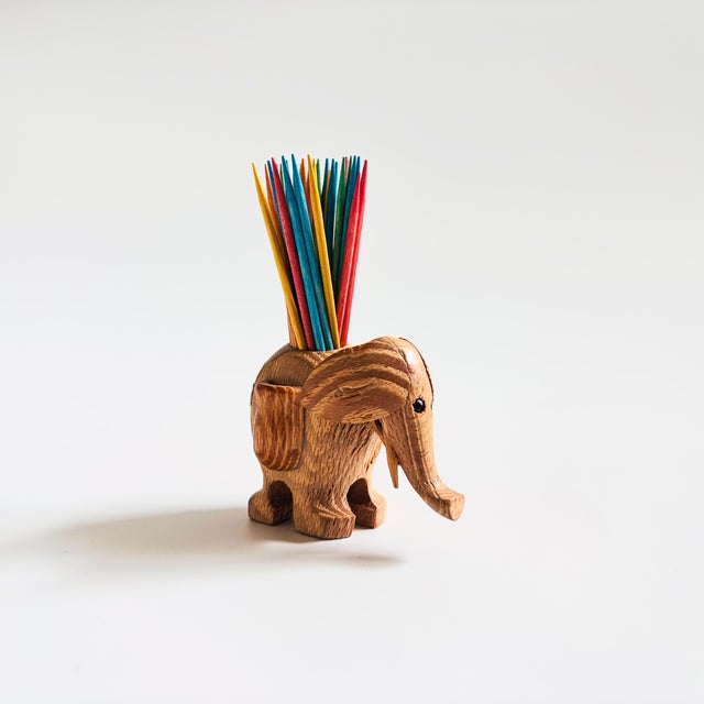An adorable Mid Century elephant toothpick holder. Lovely natural grain to the wood. A hole is formed in the center for...