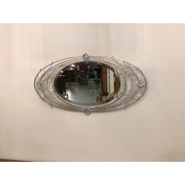 French Art Deco wall mirror with geometric and floral motif details. Can be hung vertically or horizontally. The frame has...