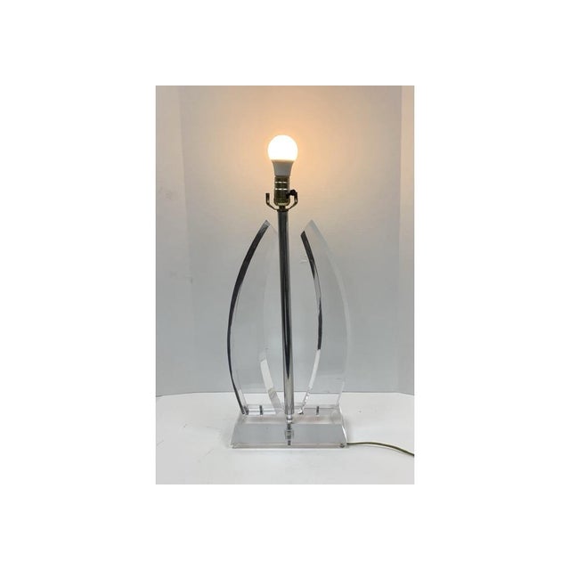 The lamp features two clear curved lucite panels around the central stem. The panels with dual sail or wing-like...