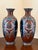 This is a pair of late 19th-century baluster Japanese cloisonné enamel vases, decorated in a deep burgundy red ground....