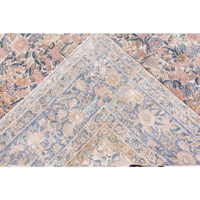 A late 19th century antique Persian Kirman carpet the ivory field with enlarged split-leaf tendrils, rosettes and floral...