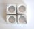 A set of 4 vintage white marble napkin rings with grey veins, square on the outside and round on the inside.