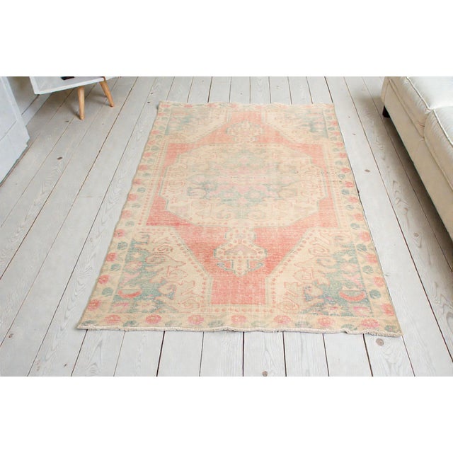 This is a vintage Turkish Oushak rug from the Mid 20th Century. The piece was hand-knotted.