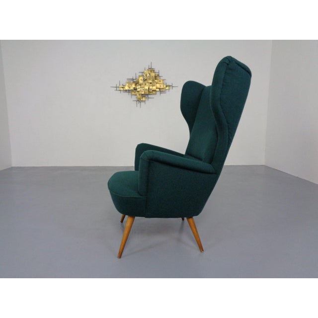 French wingback chair from the 1950s, upholstered in dark green Kvadrat Tonica fabric and completely reupholstered....