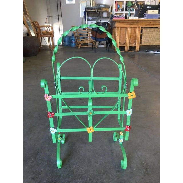 Mid-century era magazine wrought iron stand with twist accents, decorative heart center, and floral pattern throughout....