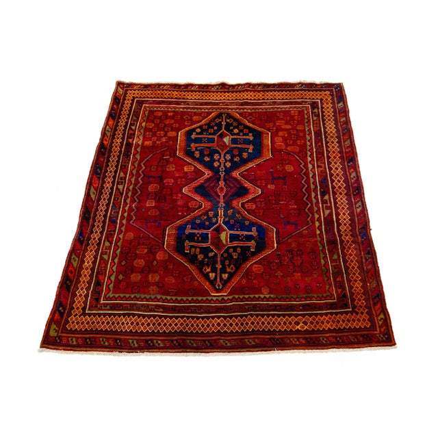 Vintage Hand-knotted Persian Shiraz Wool rug. This rug has a red field and navy blue accents in an over-tribal motif. this...
