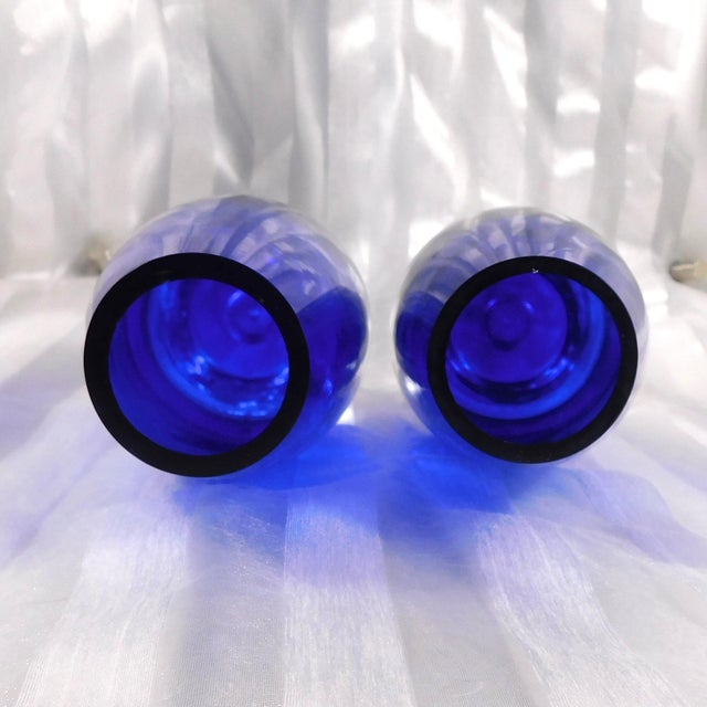 This is a pair of two blue medium size vases on clear bases with bubbles in the base. I do not see any markings on the...