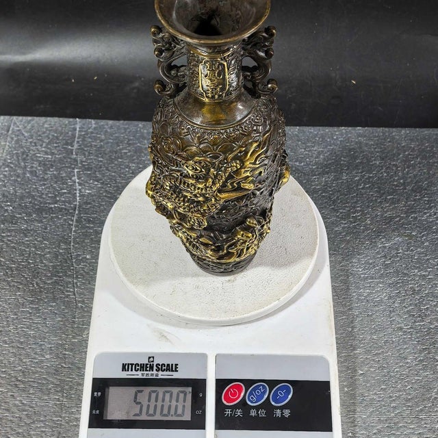 A striking Chinese bronze vase featuring deep relief carvings and extensive gold (gilt) detailing. The vase has a flared...