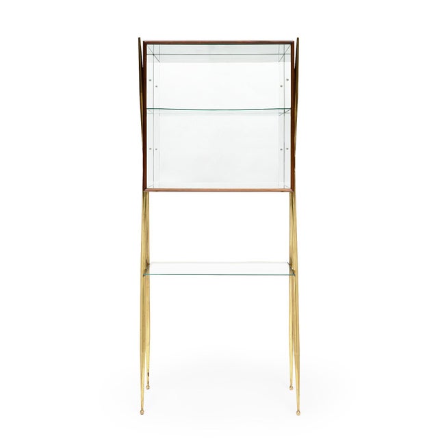 Elegant Italian mid-century bar cabinet in the manner of Gio Ponti. Distinguished by a sculptural wooden case made of...
