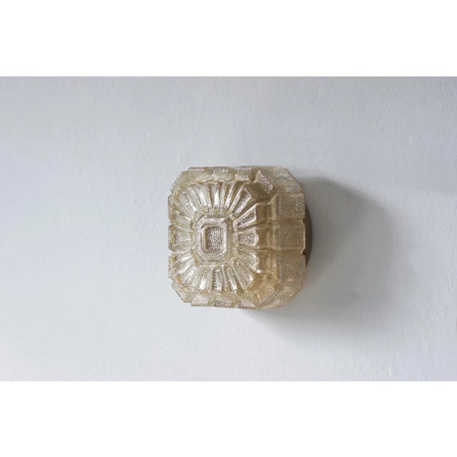 A stylish ceiling lamp made of amber glass in warm, golden tones, which perfectly reflects the mid-century modern...