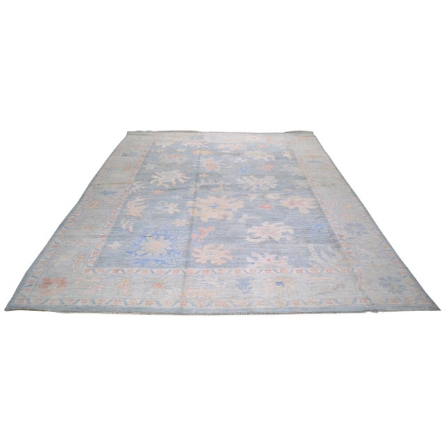 Oushak hand knotted wool rug with natural colors, floral style, and fine weave.